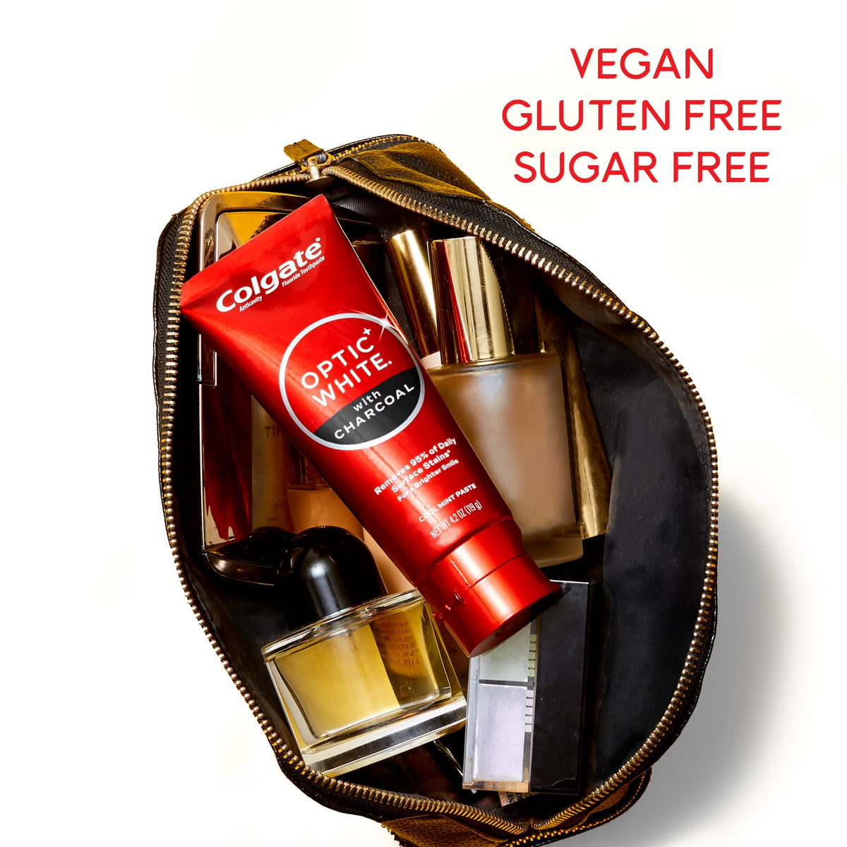Open makeup bag with Colgate toothpaste, perfume, and other items on a white background.