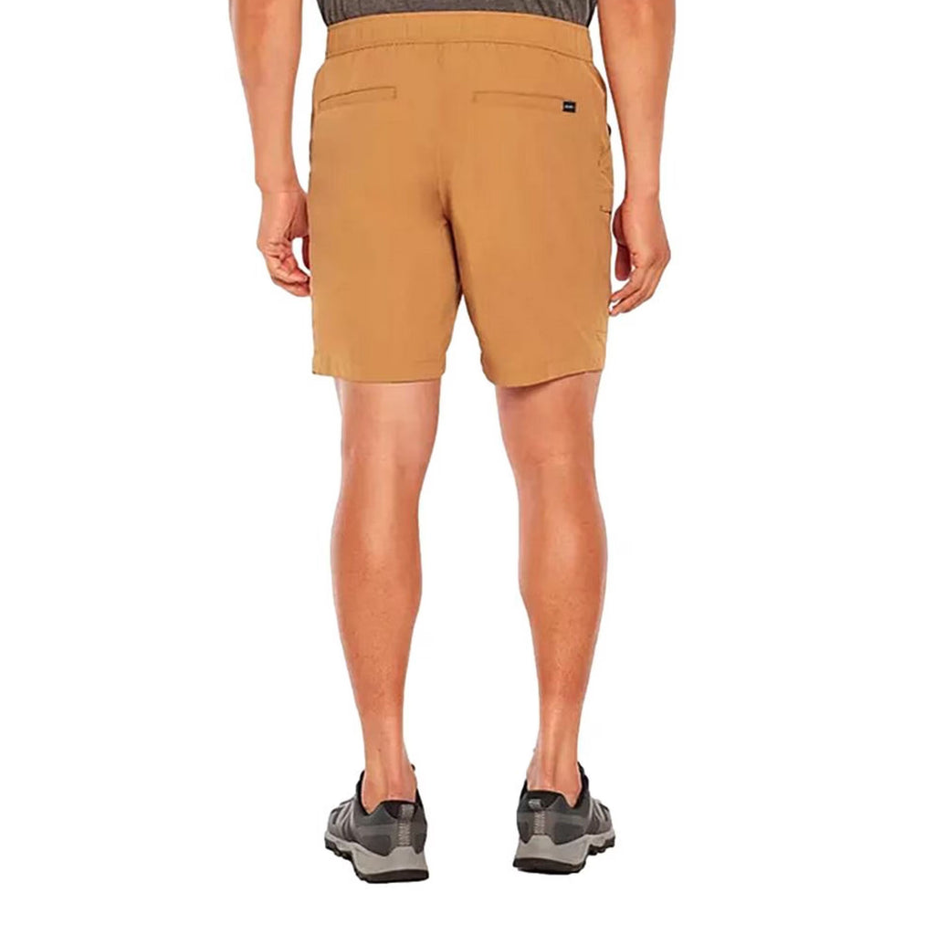 A man viewed from the back wearing tan hiking shorts, gray and black trail shoes, and a dark gray shirt against a plain white background.